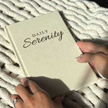 Photo of Daily Serenity Journal being held in between womens hands